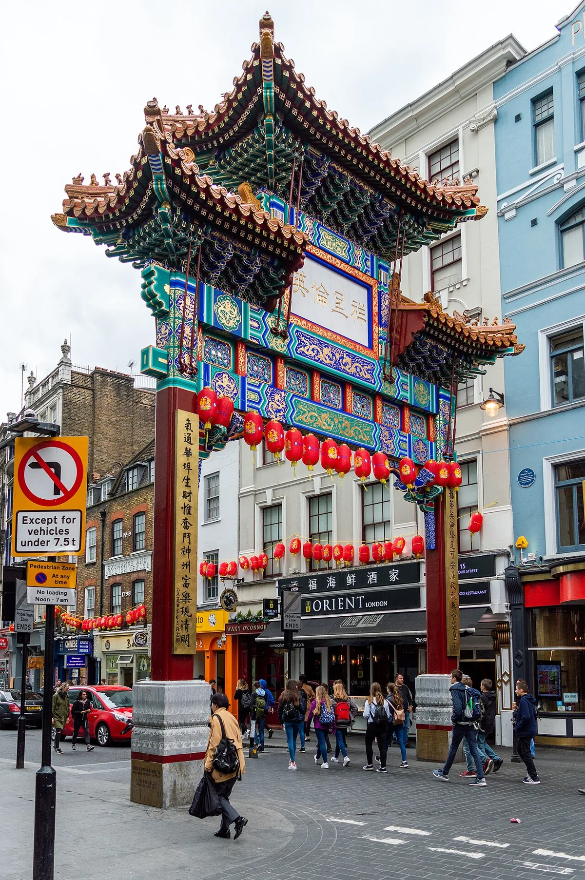 L'arche chinoise de Chinatown enjambe une rue commerçante londonienne bordée d'immeubles européens.