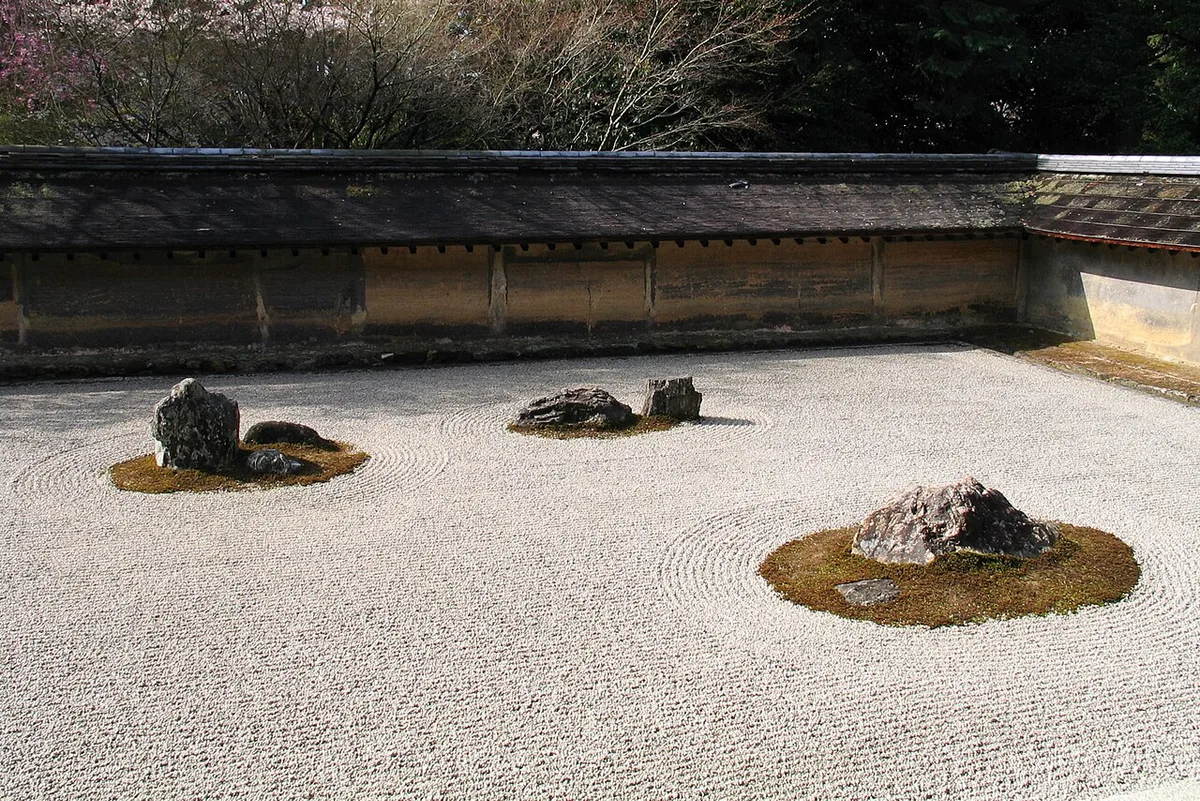 Le jardin sec du Ryōan-ji à Kyoto : quelques rochers posés sur un rectangle de gravier ratissé.